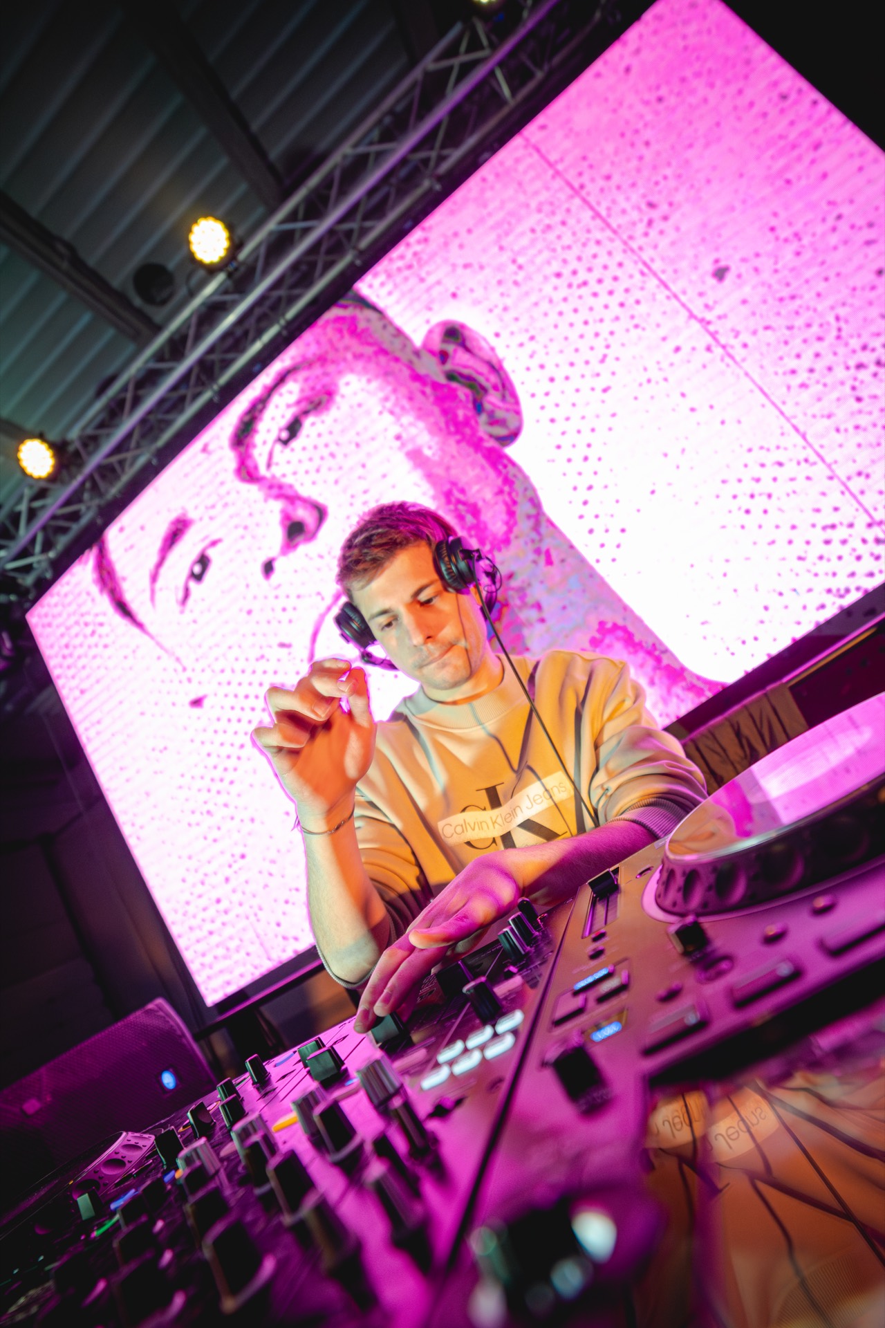Aaron MVP DJ bajo luces rosas en festival
